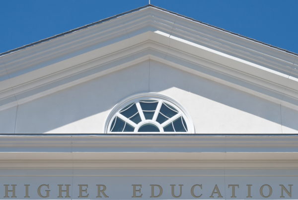 Greek-style architecture with the words "Higher Education" running across the bottom of an arch.