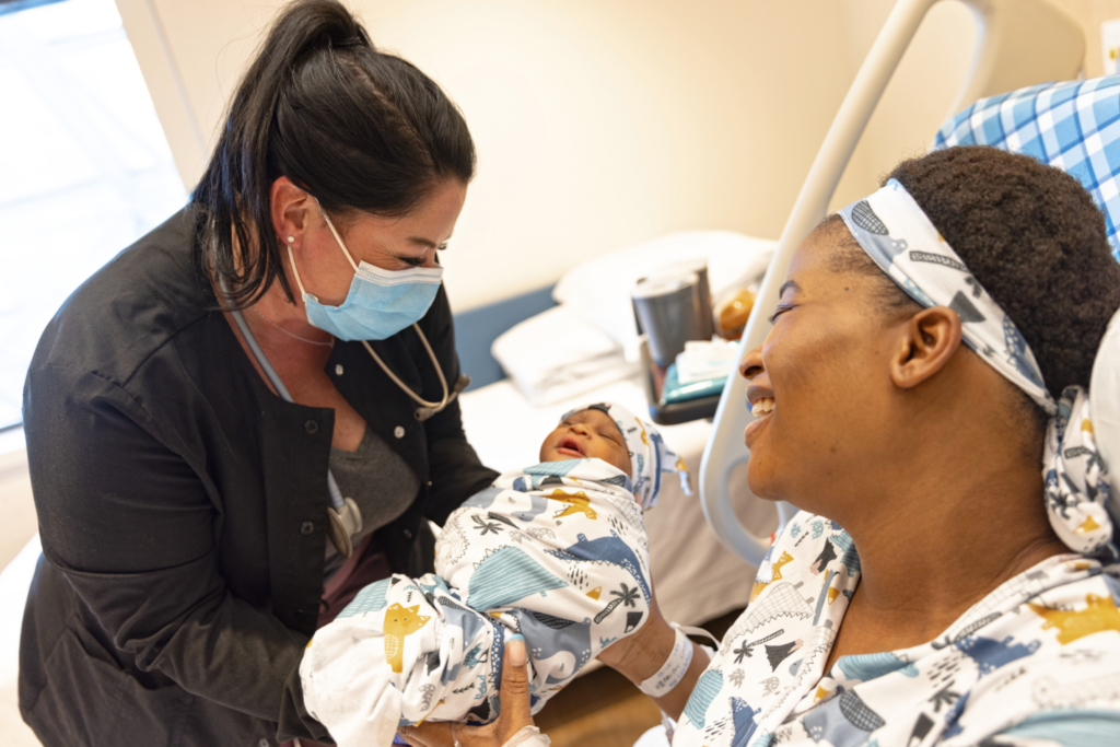 A new mother receives her baby after giving birth in a hospital.